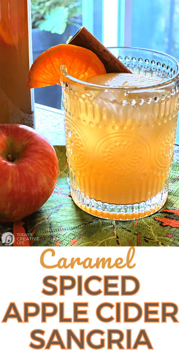 Glass of Apple Cider Sangria with an orange and cinnamon stick garnish.