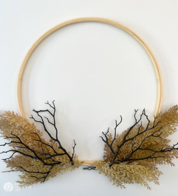 Adding black twigs to the wreath form for a halloween wreath.