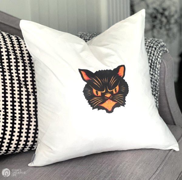 White pillow with vintage black cat face for Halloween decorating ideas.