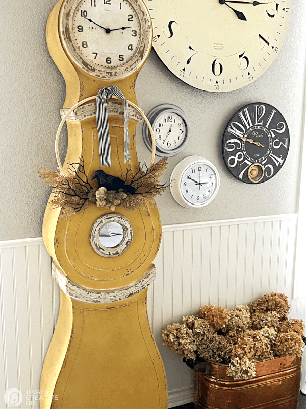 Swedish Mora Clock with crows nest wreath hanging on it. Halloween Decor DIY.