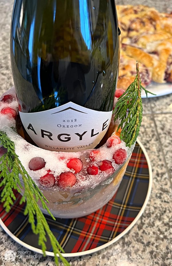 Wine bottle in a DIY Ice Bucket with cedar and cranberries.