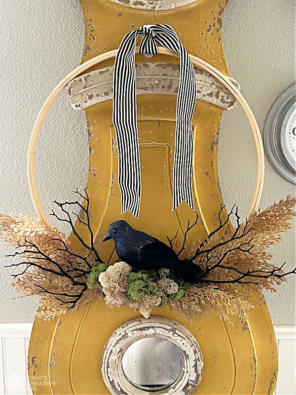 Crows Nest Wreath hanging on a gold painted Swedish Clock