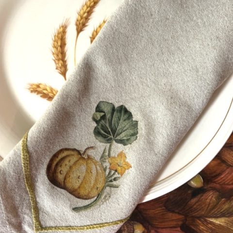 Folded cloth napkin with ironed on pumpkin design for Thanksgiving table