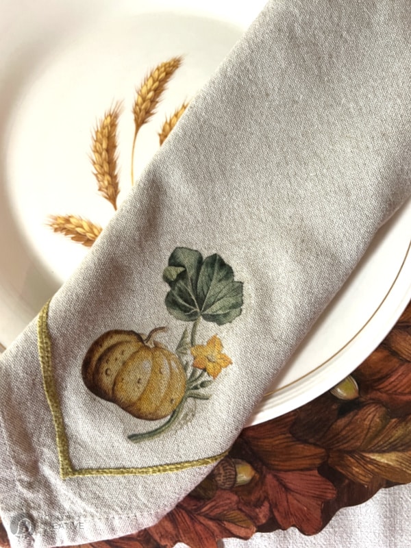 Folded cloth napkin with ironed on pumpkin design for Thanksgiving table
