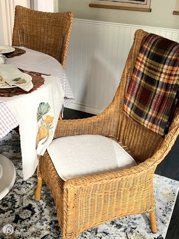 wicker dining chair at table with table runner for thanksgiving