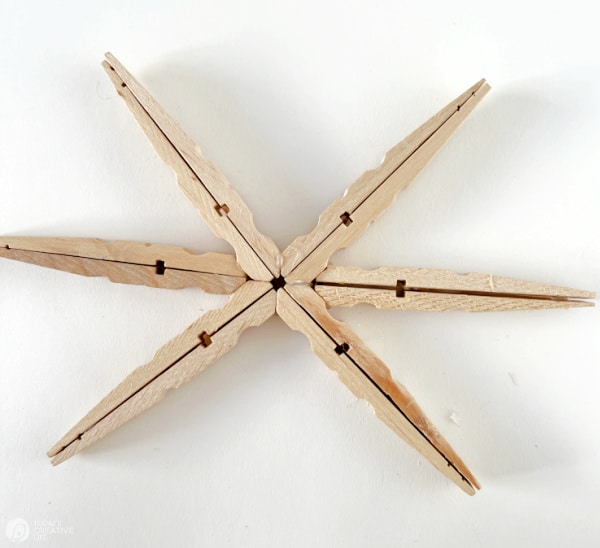 Steps for making DIY Snowflake Christmas Ornaments made from wood clothes pins.