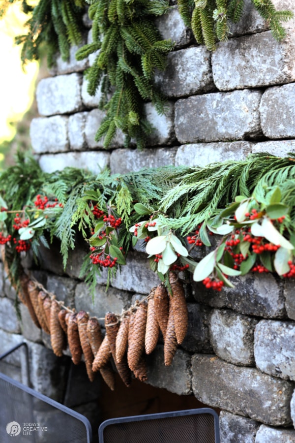 outdoor fireplace with pinecone garland