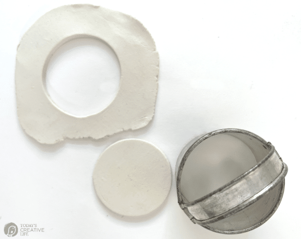 White clay and a round cookie cutter with round shapes.