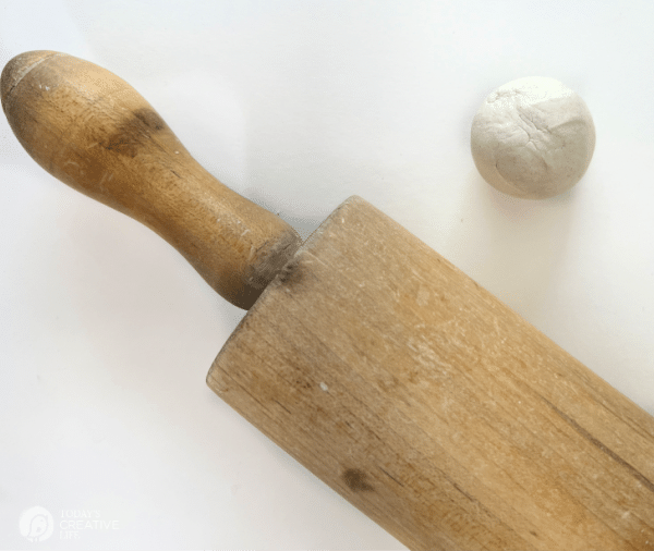 Rolling pin with a ball of white clay.