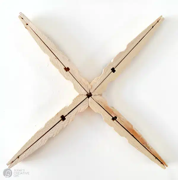DIY Snowflake Christmas Ornament Steps for gluing clothespins together.