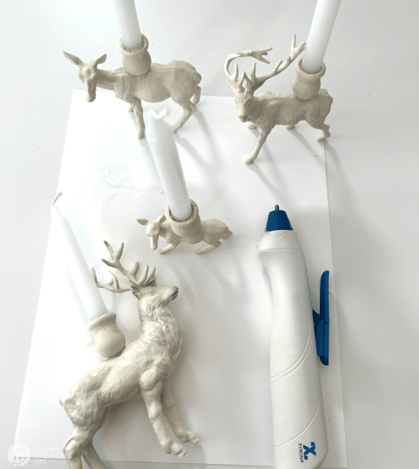 White spray painted plastic animals for DIY Reindeer Candle Holders