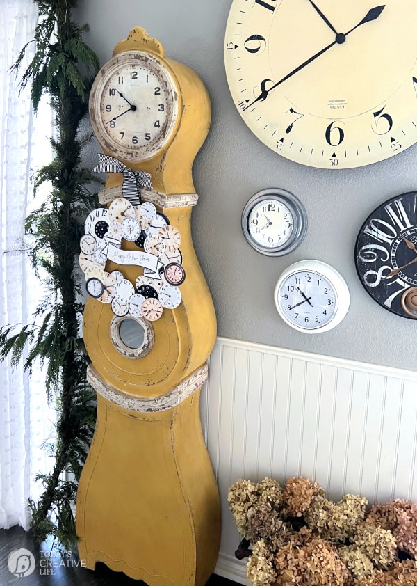 Gold grandfather clock with clock face wreath hanging on it for New Year's Eve Crafts