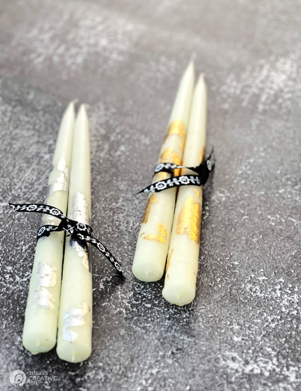 Two pair of taper candles that have gold leafing 