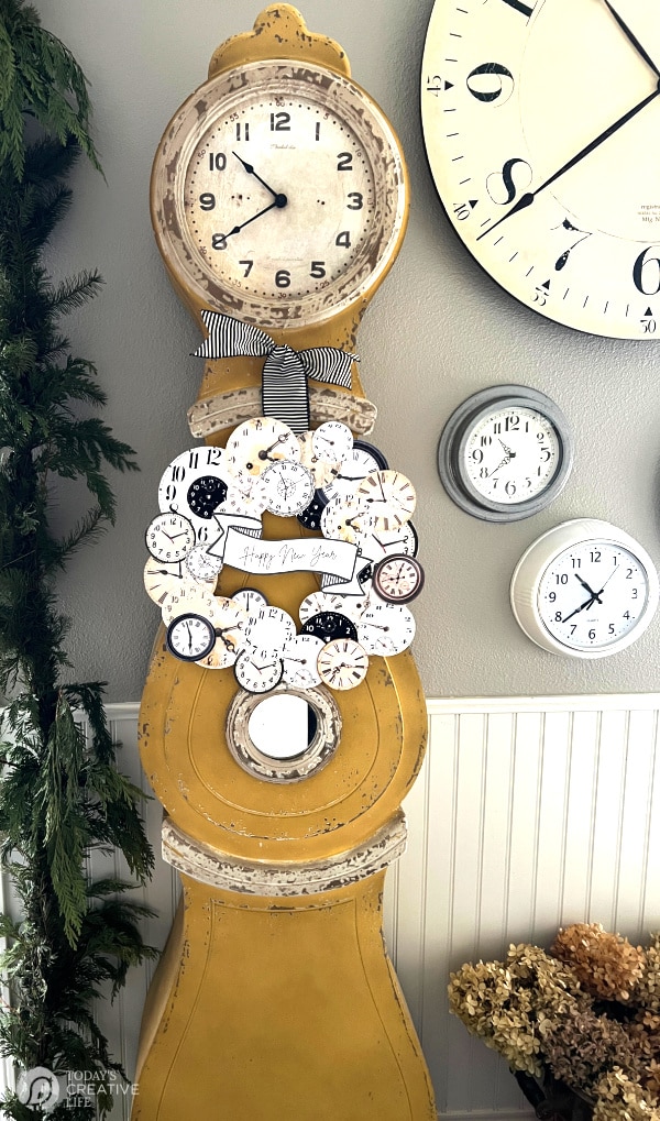 Gold Swedish grandfather clock with NYE wreath hanging on it. 