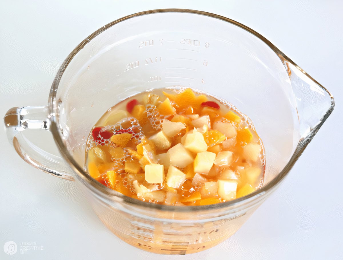 Glass clear bowl with fruit cocktail inside.