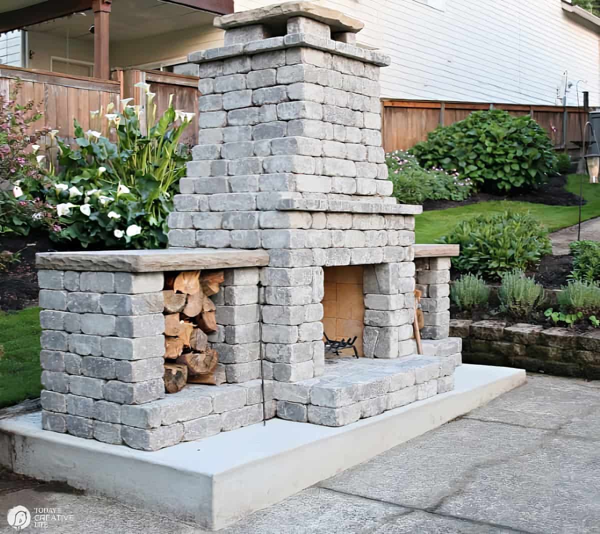 Grey stone backyard fireplace with wood boxes